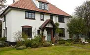 Black timber double glazed casement windows and wooden front door with georgian bars from the Anglian wooden windows and doors range